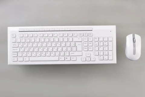 White keyboard and optical mouse on table. Photos