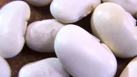 White kidney beans rotating macro shot on wooden background Stock Footage 338126736