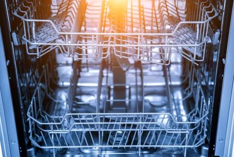 The white kitchen and opened dishwasher with clean dishes Stock Photos