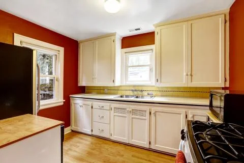White kitchen cabinets with bright red wall Stock Photos