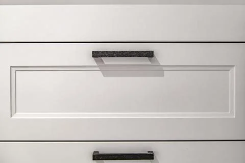 White kitchen cabinets with metal pulls or knobs on the doors. Foto stock