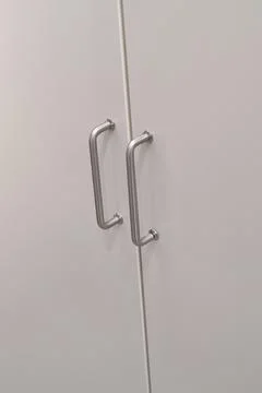 White kitchen cabinets with metal pulls or knobs on the doors Foto stock
