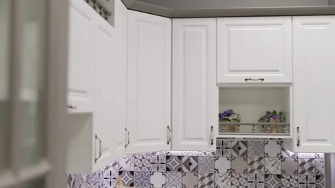 White kitchen cabinets opening and closing, revealing decorated backsplash Stock Footage 304867052