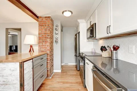 White kitchen room interior with grey details. White backsplash , glossy coun Stock Photos