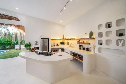 White kitchen with stone table with gas stove. Overlooking the pool in the ga Stock Photos