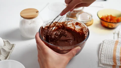 On white kitchen table among ingredients for homemade baking, female hands a Stock Footage 247364666