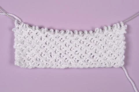 White knit stitch pattern sample on purple background Stock Photos