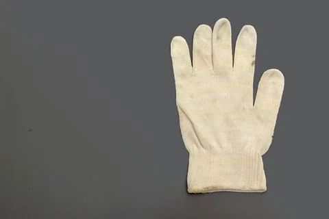 White knitted working glove with stretchable cuff on the dirty gray backgro.. Stock Photos