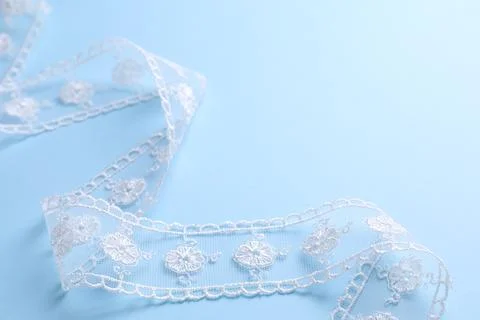 White lace on light blue background, closeup Stock Photos