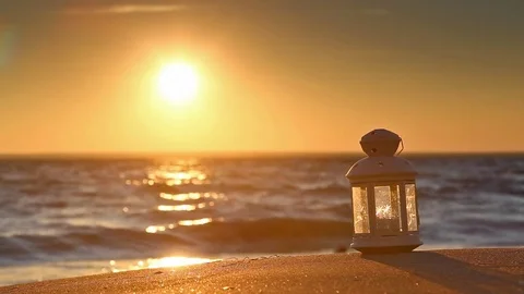 White lantern on the beach at sunset 스톡 동영상 70548454