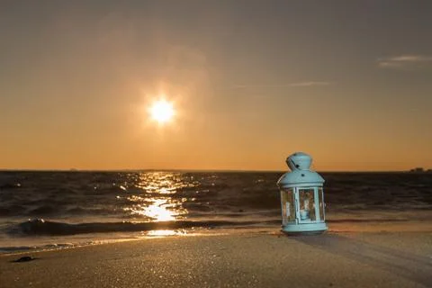 White lantern on the beach at sunset Stock Photos