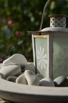 A white lantern in a dish filled with white stones from the beach, Amorgos Stock Photos