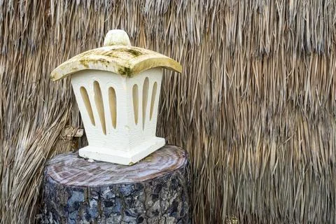 White lantern sits on a log Stock Photos