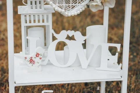 White lanterns sit beside a delicate "LOVE" sign Foto stock