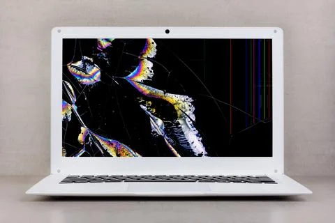 White laptop with a broken screen on a gray background close-up front view Stock Photos