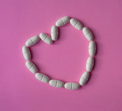 White, large pills or tablets, arranged in a heart shape to represent health Stock Photos
