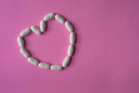 White, large pills or tablets, arranged in a heart shape Stock Photos
