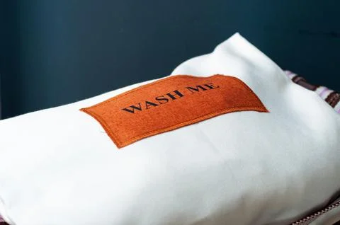 White laundry bag on black background with text 'wash me' Stock Photos