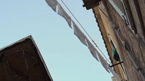White laundry is drying on a rope against the background of old brick buildings Stock Footage 211893707