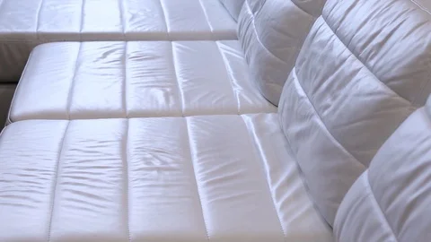 White leather sofa shallow texture slow tilting video . Leather beige sofa rough Stock-Footage 104278353