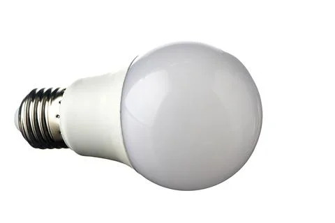 A white LED lamp with an E27 base lies on a white insulated background Stock Photos