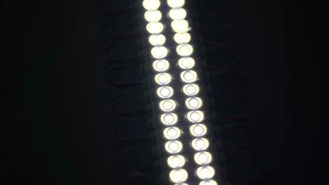 White Led strip closeup. Diode shining stripe on dark background. 動画素材 113011640
