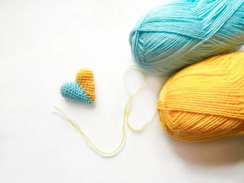 On a white lies two coils of thread, blue and yellow with loose thread and a  Stock-Fotos