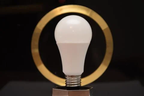 White light bulb on black background with gold circle Stock Photos