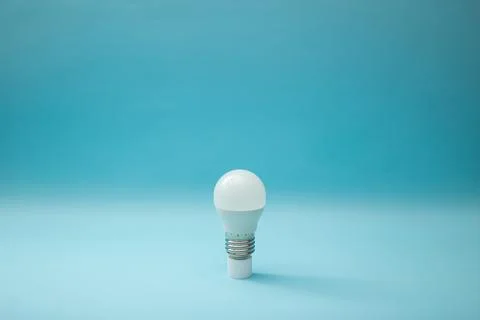 White light bulb on a blue background Stock Photos
