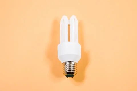 White light bulb on bright orange background in pastel colors. Minimalist con Stock Photos