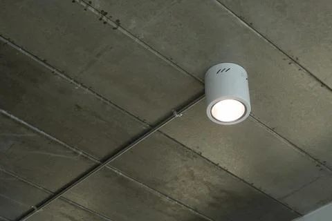 White light bulb on grey ceiling, interior design Stock Photos