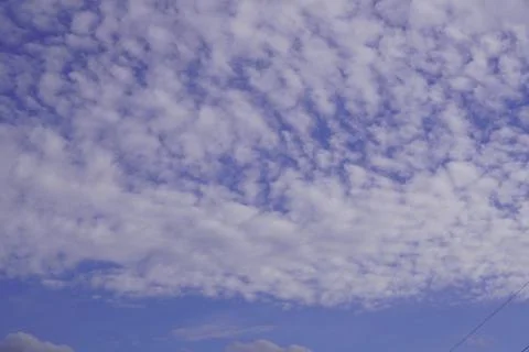 White light fluffy clouds in a blue sky with a solar flare. Foto stock