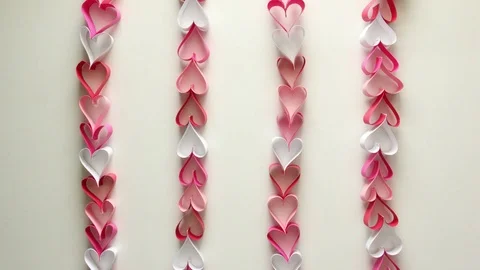 White, light pink, dark pink and red paper heart chain stop motion animation Stock Footage