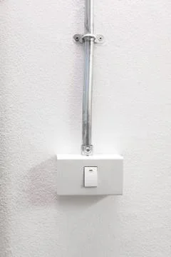 White light switch  with Electrical conduit pipe on wall Stock Photos