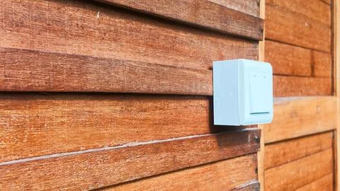 White Light Switch Mounted on Brown Wooden Siding Wall Surface Stock Photos