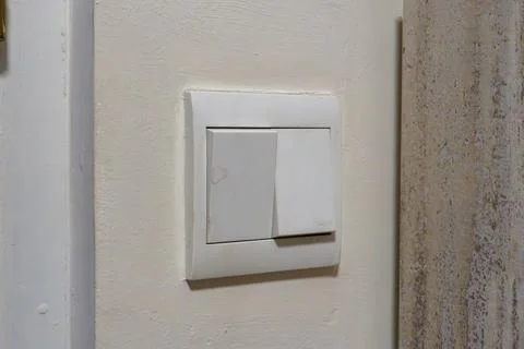White light switch mounted on textured wall Stock Photos