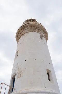 White lighthouse and cloudy sky as a background Stock Photos
