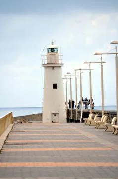 White lighthouse at the bottom of the road Stock Photos