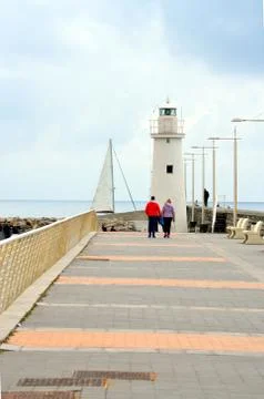White lighthouse at the bottom of the road Stock Photos
