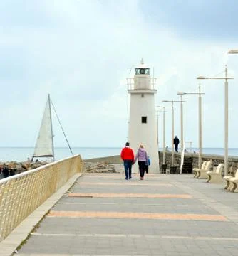 White lighthouse at the bottom of the road Stock Photos
