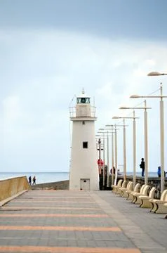 White lighthouse at the bottom of the road Stock Photos
