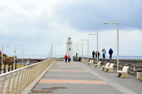 White lighthouse at the bottom of the road Stock Photos