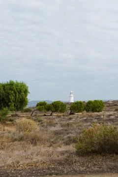 White lighthouse far away in cloudy weather Stock Photos