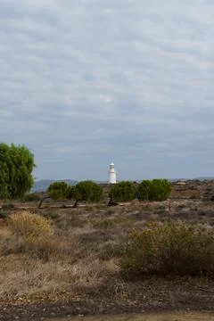 White lighthouse far away in cloudy weather Stock Photos