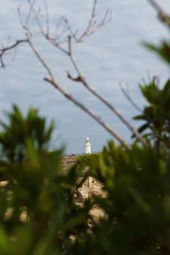 White lighthouse far away in cloudy weather Stock Photos