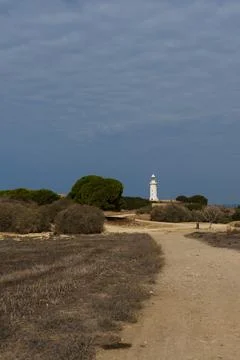 White lighthouse far away in cloudy weather Stock Photos