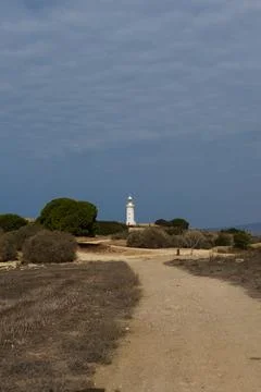 White lighthouse far away in cloudy weather Stock Photos