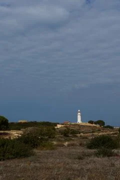 White lighthouse far away in cloudy weather Stock Photos