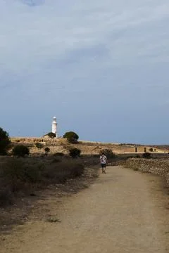 White lighthouse far away in cloudy weather Stock Photos