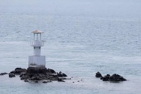 White Lighthouse in the sea. Stock Photos
